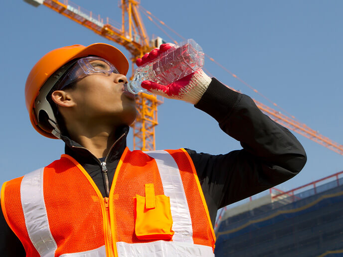 Bauarbeiter trinkt Wasser im Sommer
